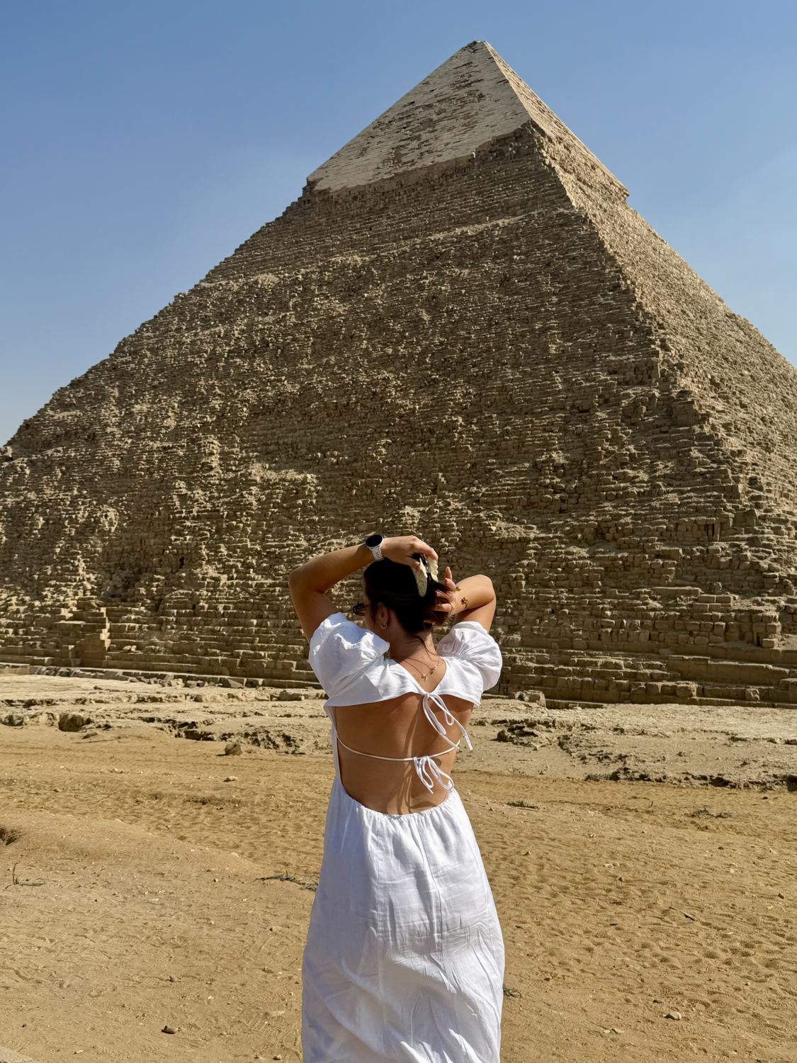 Anna in a white linen dress in front of the Pyramid of Khafre under a blue sky